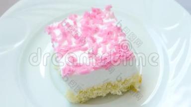 带粉红色薯<strong>片</strong>装饰的奶油蛋糕在白色盘子上旋转
